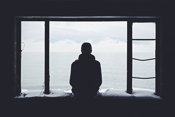 Άντρας με κατάθλιψη κάθεται στο παράθυρο